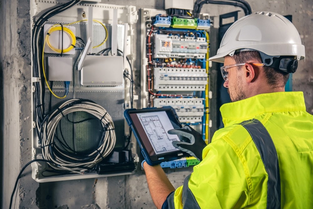 Professional electrician in Brisbane conducting an electrical inspection using a digital tablet