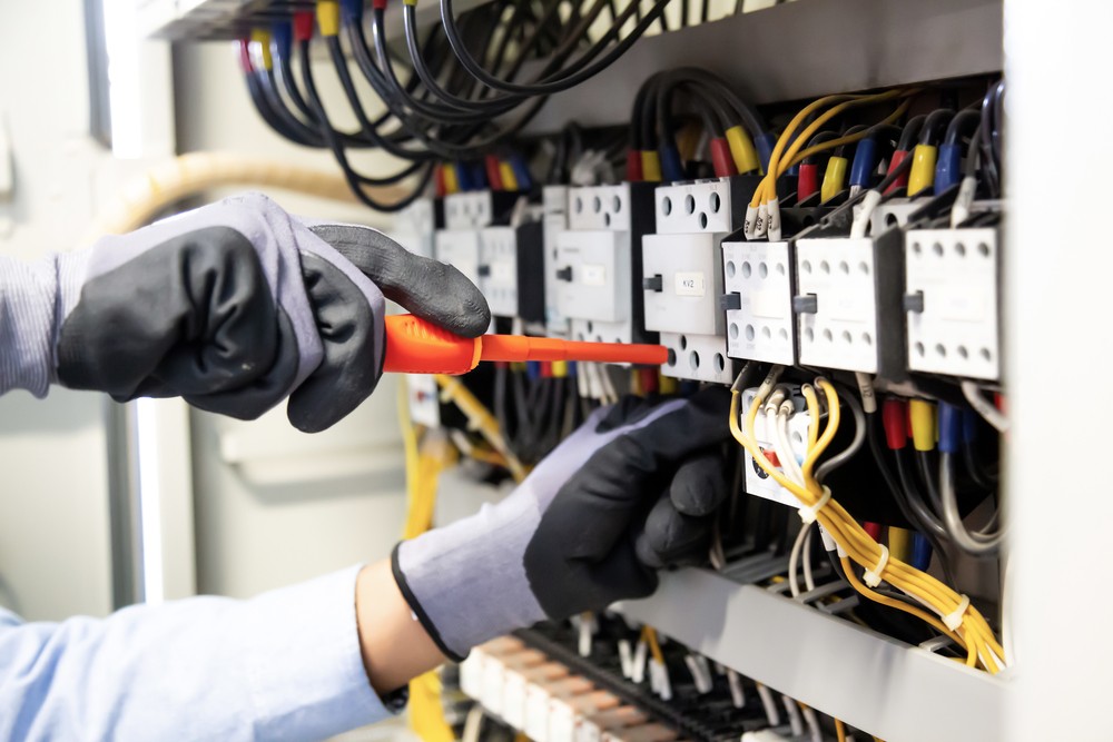 Industrial electrician in Brisbane adjusting a complex control panel
