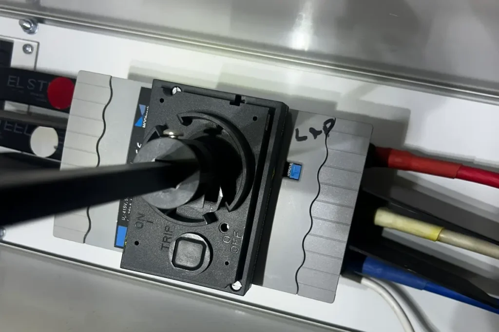 Three-phase isolator mounted inside Brisbane main switchboard MSB internals showing cables connected and proper clearances by SEQ Sparky compliant with AS NZS 3000